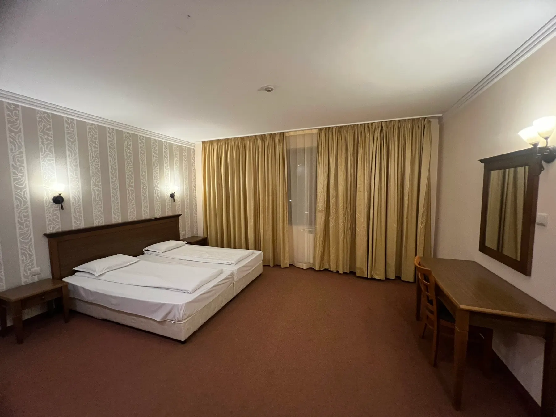 Junior suite — the bedroom with two single beds, a mirror and a desk